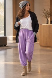 Lila haremsbyxa i hotellfoajé, vänd pose