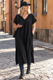 Svart klänning med blå jeans, i höstsol